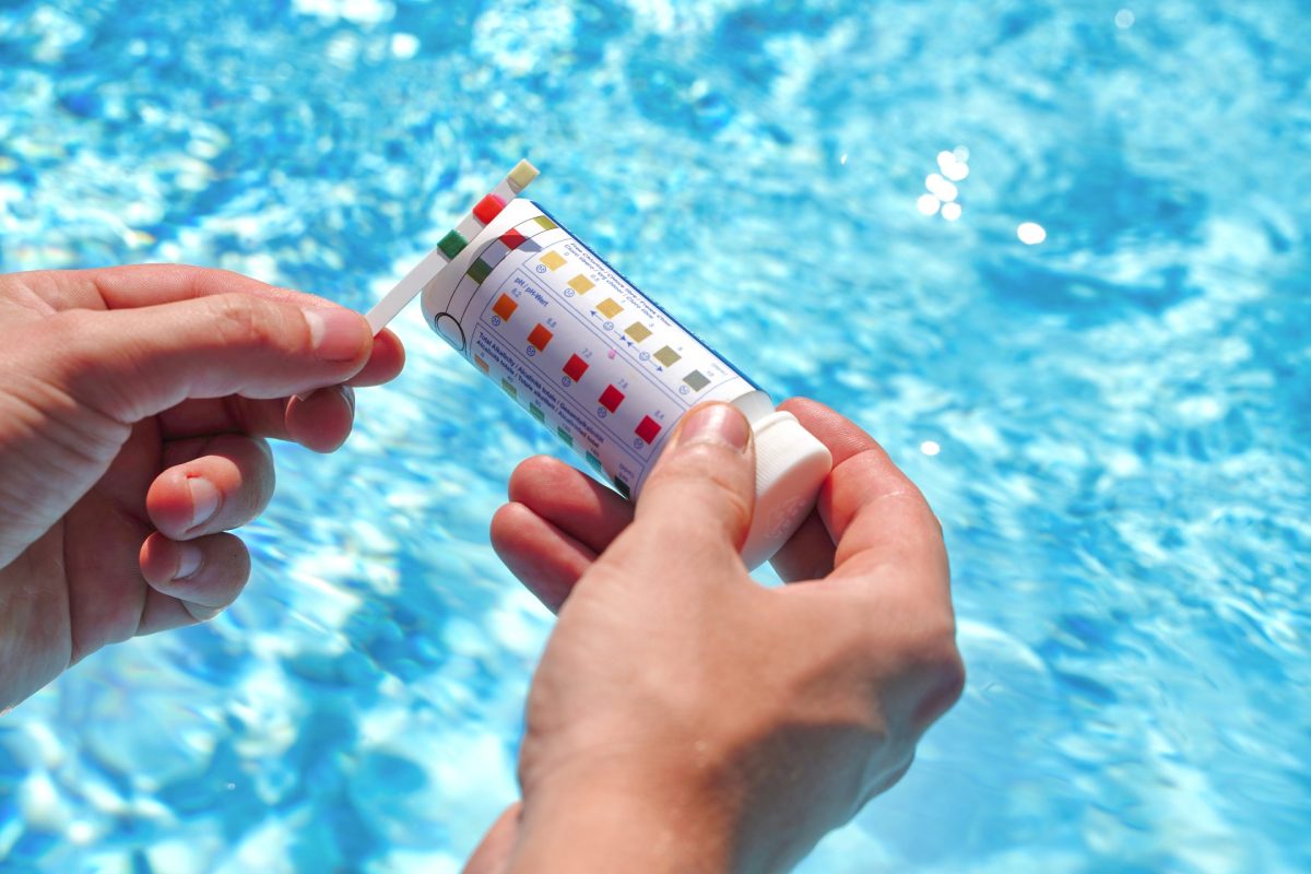 Poolpflege: Überprüfung der Wasserqualität eines Pools mithilfe eines Teststreifens für pH-Wert, Chlor und Algizid | Foto: stock.adobe.com