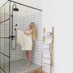 Moderne Glasabtrennungen für Duschen: Funktionalität und Ästhetik im Badezimmer junge frau will duschen